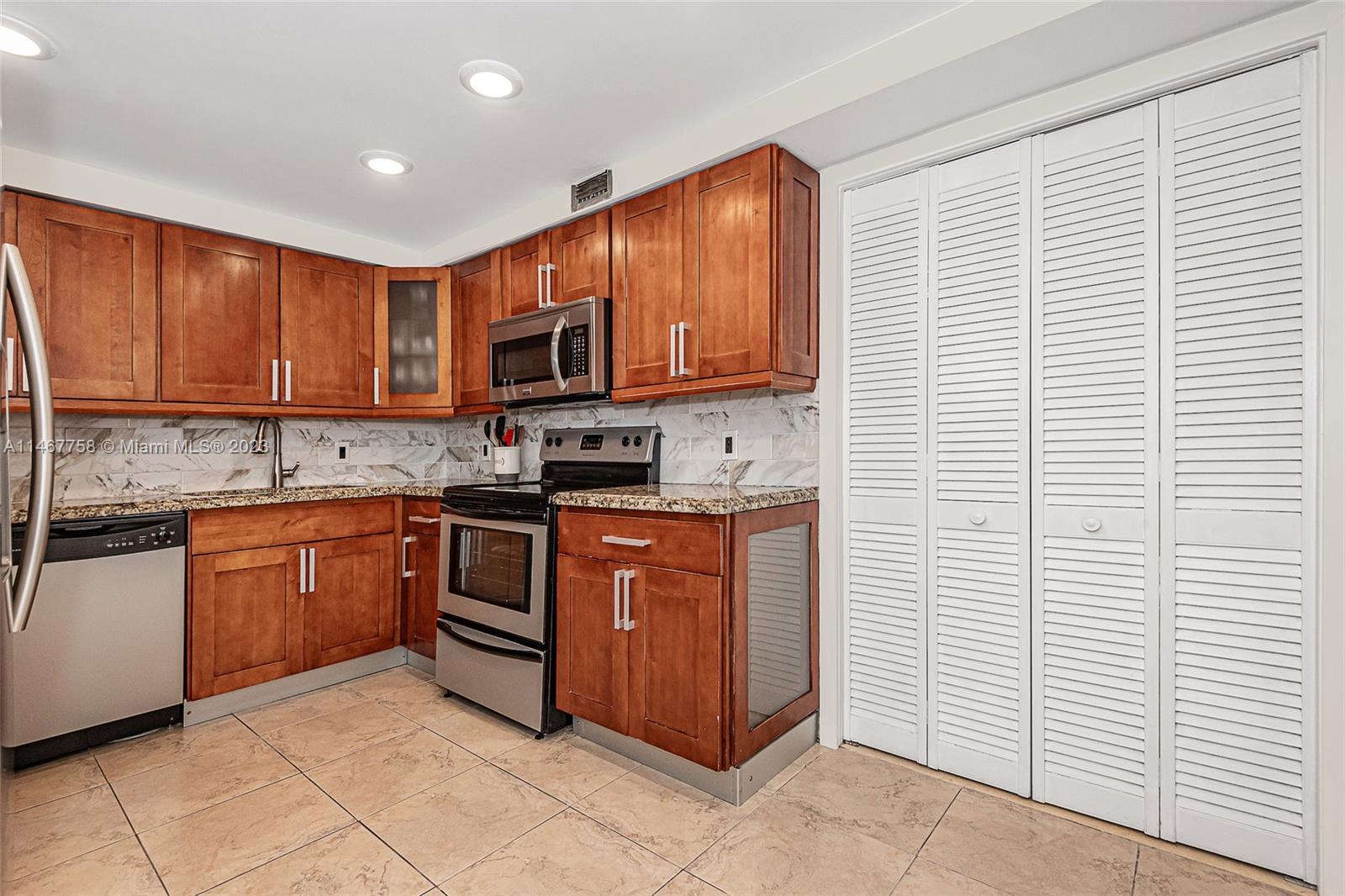 16401 Golf Club Road, Unit 311 Weston, FL 33326 - Photo 14 of 33 a kitchen with stainless steel appliances granite countertop a stove a sink and a microwave