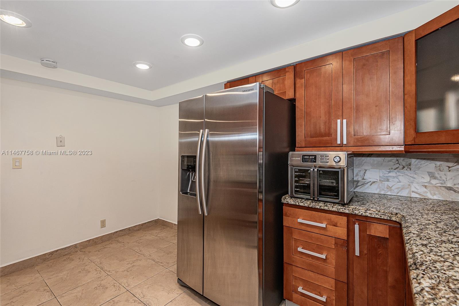 16401 Golf Club Road, Unit 311 Weston, FL 33326 - Photo 15 of 33 a kitchen with stainless steel appliances granite countertop a refrigerator and a stove top oven