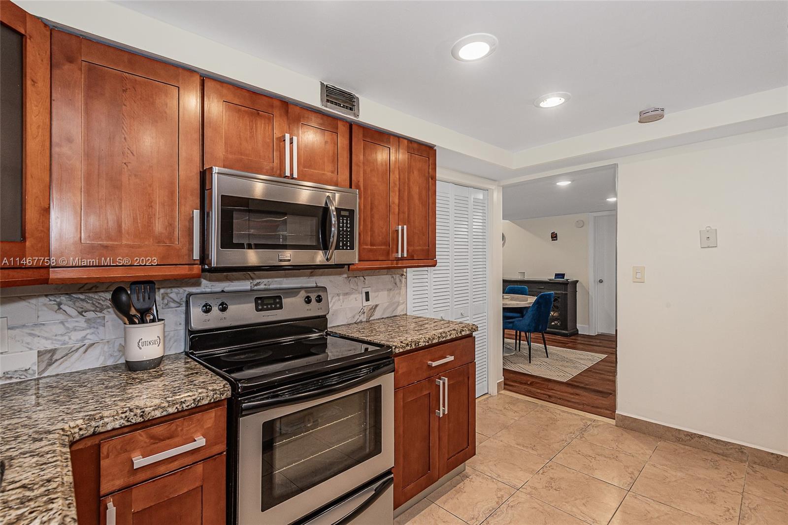 16401 Golf Club Road, Unit 311 Weston, FL 33326 - Photo 16 of 33 a kitchen with stainless steel appliances granite countertop wooden cabinets a stove top oven a sink and dishwasher