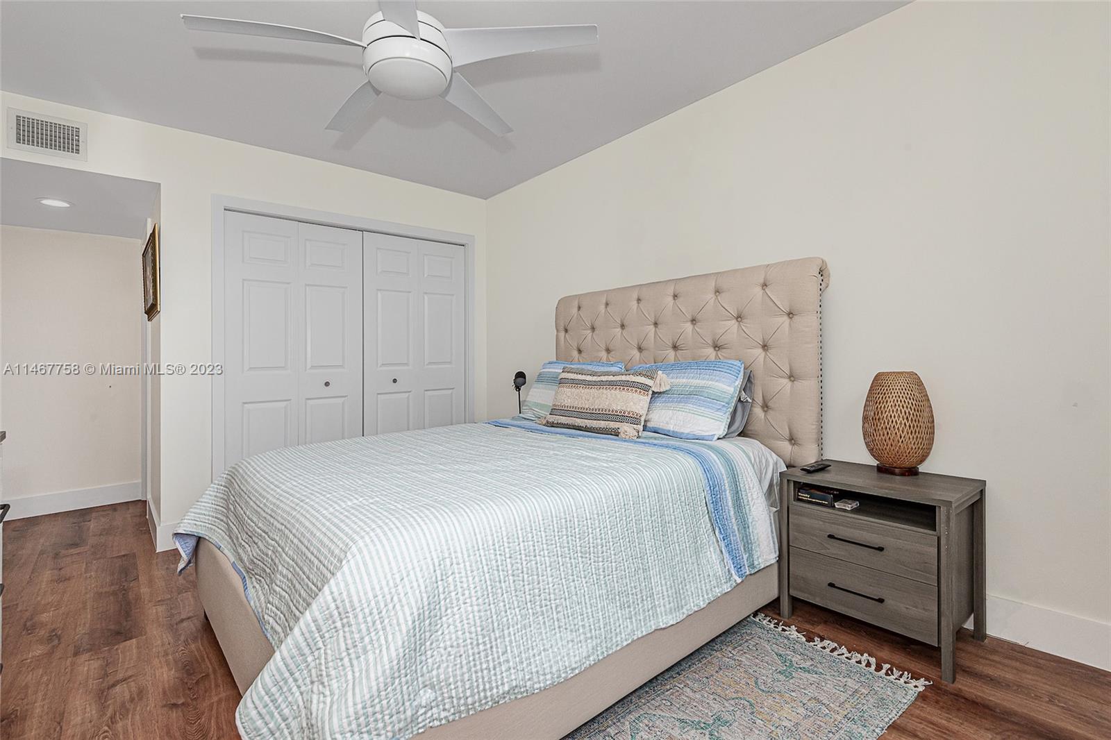 16401 Golf Club Road, Unit 311 Weston, FL 33326 - Photo 21 of 33 a bedroom with a bed and wooden floor