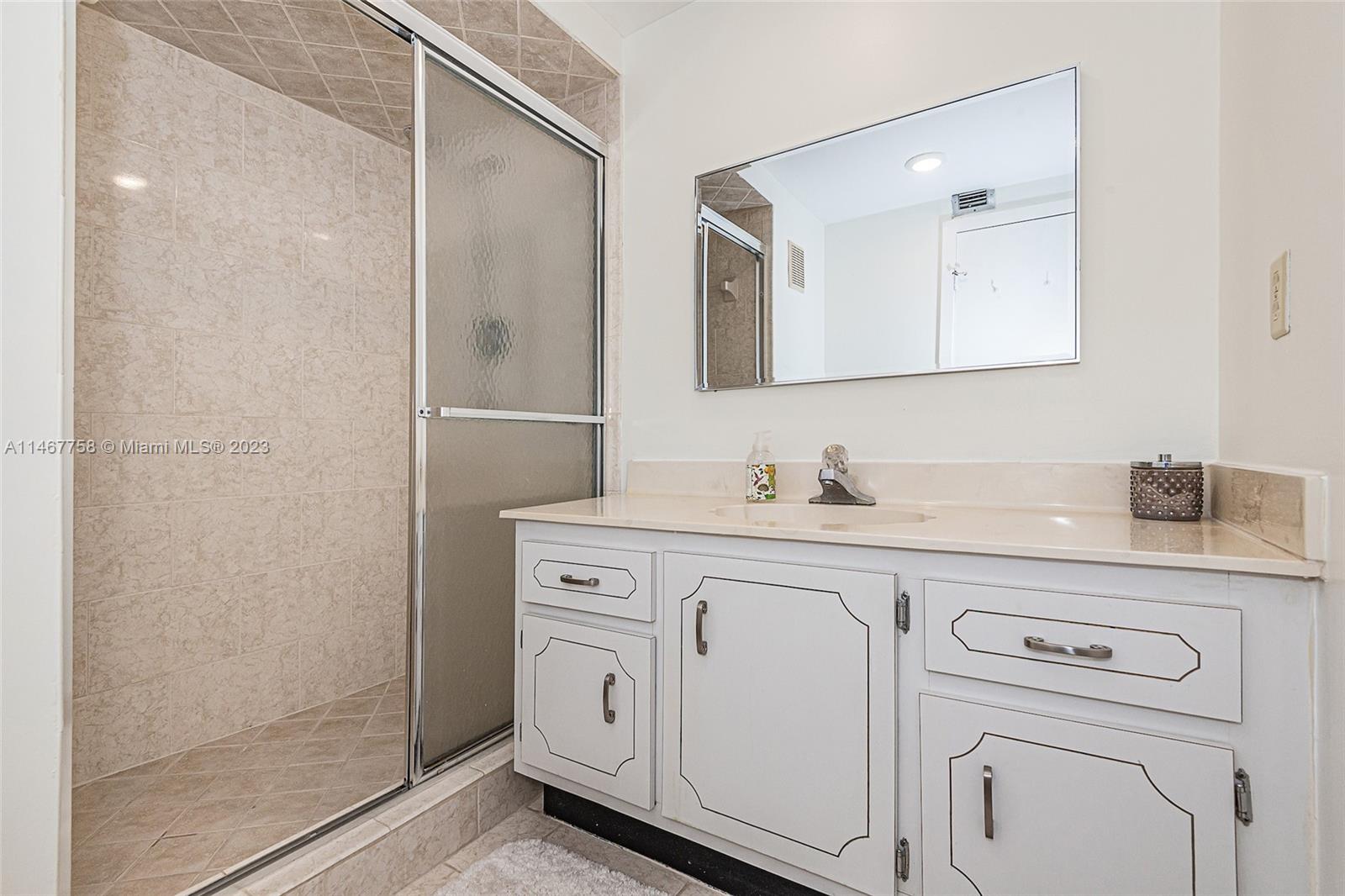 16401 Golf Club Road, Unit 311 Weston, FL 33326 - Photo 22 of 33 a bathroom with a sink a vanity and a mirror
