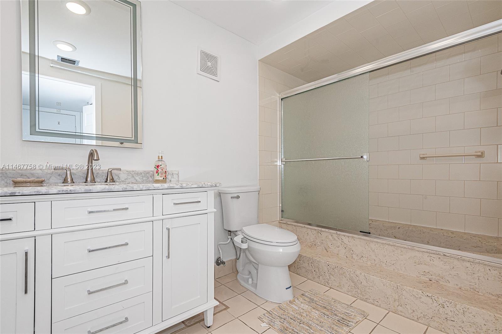 16401 Golf Club Road, Unit 311 Weston, FL 33326 - Photo 27 of 33 a bathroom with a granite countertop sink toilet and shower