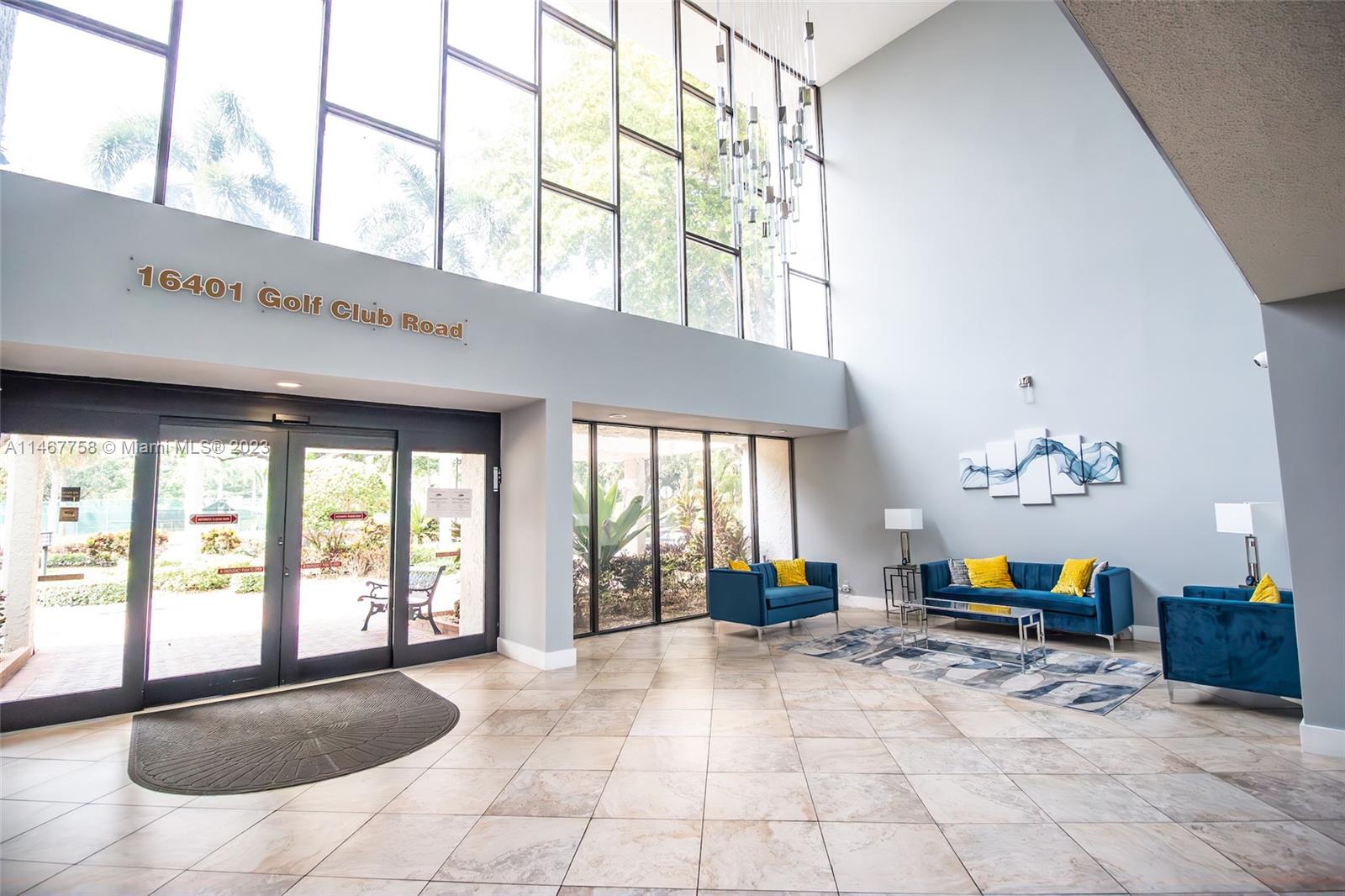 16401 Golf Club Road, Unit 311 Weston, FL 33326 - Photo 3 of 33 a lobby with furniture and floor to ceiling windows