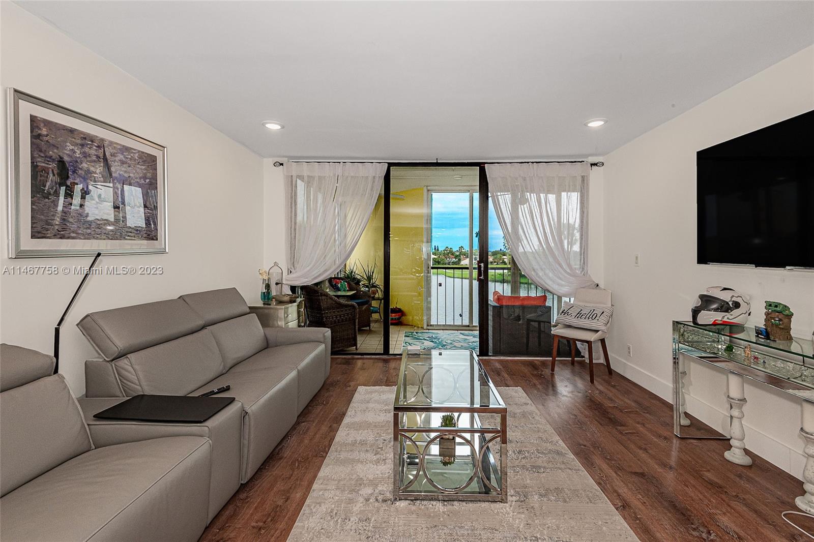 16401 Golf Club Road, Unit 311 Weston, FL 33326 - Photo 8 of 33 a living room with furniture a flat screen tv and a large window