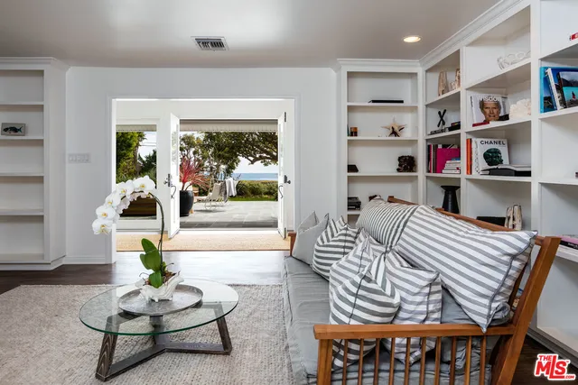 a living room with furniture a rug and a book shelf