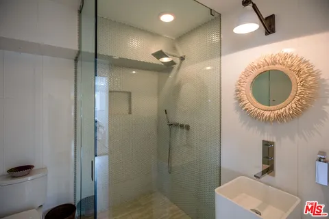 a bathroom with a mirror a sink and a shower