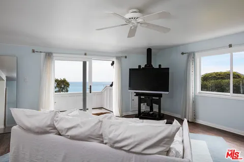 a living room with furniture tv and a window