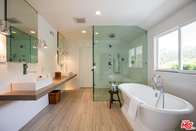 a large spacious bathroom with a large tub a sink and a large window