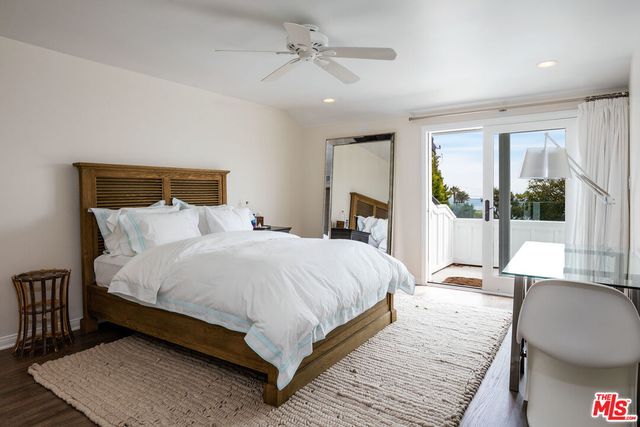 a large bedroom with a bed wooden floor and window