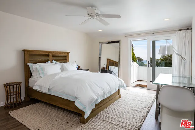 a large bedroom with a bed wooden floor and window