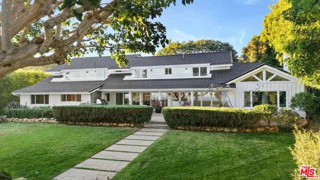 a front view of a house with a garden