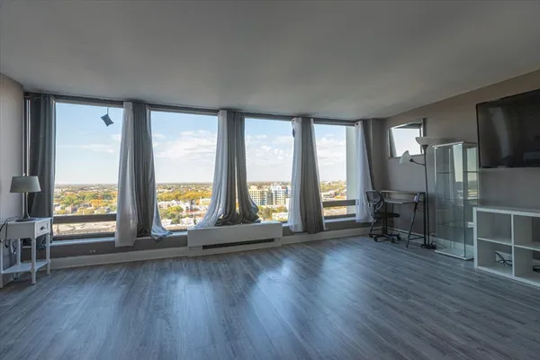 an empty room with wooden floor and windows