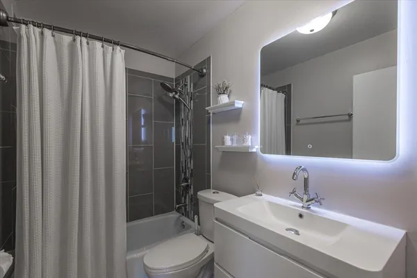 a bathroom with a sink toilet and shower