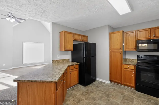 a kitchen with stainless steel appliances granite countertop a refrigerator and a stove