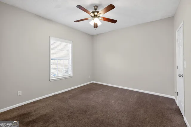 an empty room with window and a ceiling fan