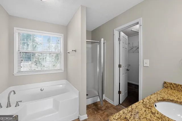 a spacious bathroom with a tub shower and sink