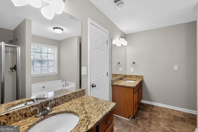 a bathroom with a granite countertop sink and a mirror