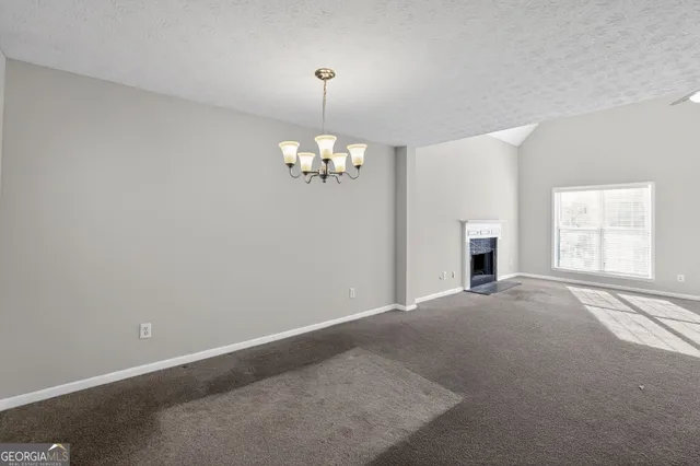 a view of an empty room with a fireplace and a window