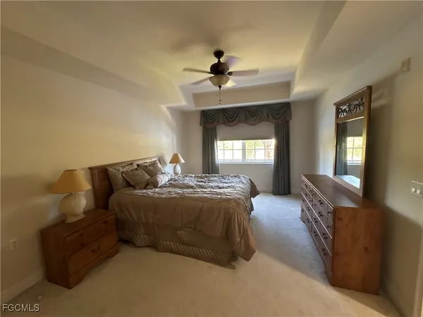 a spacious bedroom with a bed and a chandelier