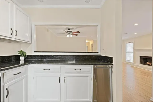 a kitchen with granite countertop a sink cabinets and stainless steel appliances