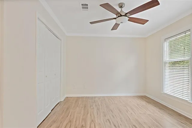 an empty room with a window and a fan