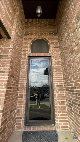 a living room with stainless steel appliances furniture a fireplace a flat screen tv and view kitchen