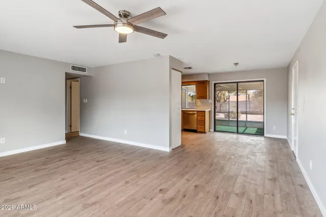 a view of an empty room with a window and wooden floor