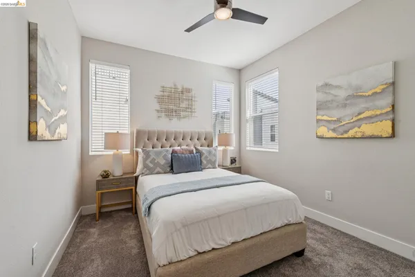 a spacious bedroom with a large bed and a chandelier
