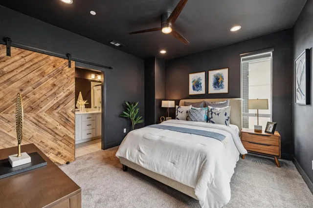 a spacious bedroom with a large bed and a chandelier