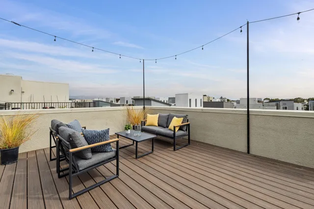 a view of a balcony dining table and chairs with wooden floor