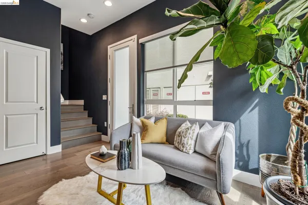a living room with stainless steel appliances kitchen island granite countertop furniture and a wooden floor