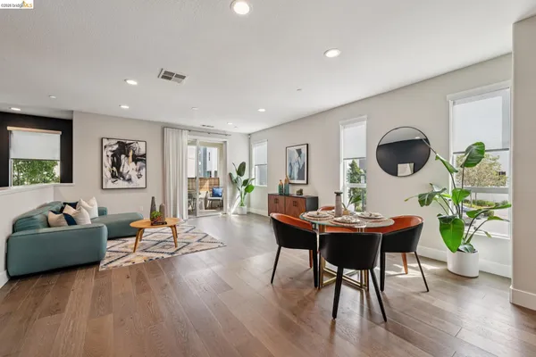 a kitchen with stainless steel appliances granite countertop a stove a sink a microwave a dining table and chairs