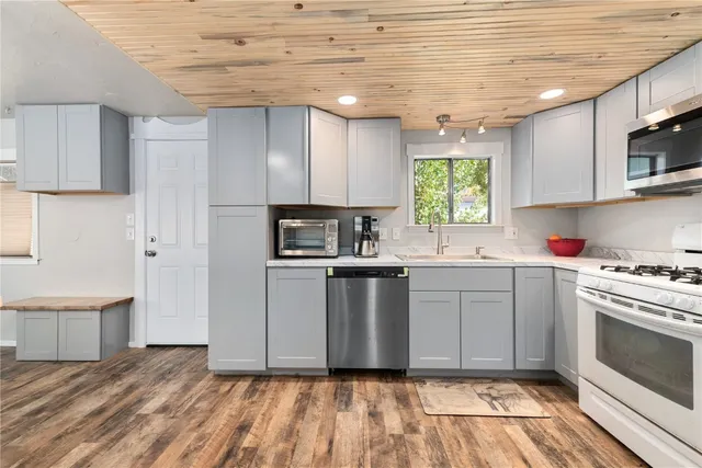 a kitchen with granite countertop a stove a sink and a microwave