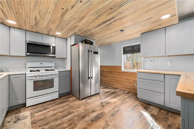 a kitchen with kitchen island a counter top space stainless steel appliances and cabinets