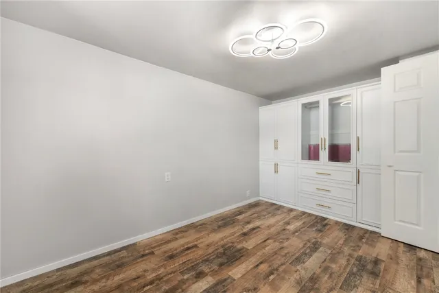 a view of a bedroom with wooden floor and cabinet