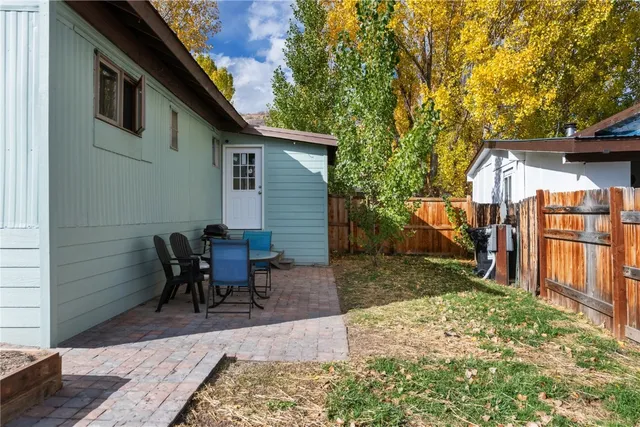 a view of a backyard with a patio area and wooden fence