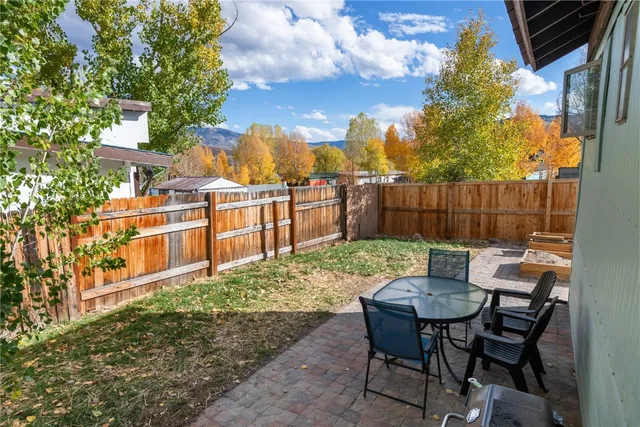 a view of a chairs and table in backyard