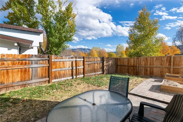 a backyard of a house with table and chairs