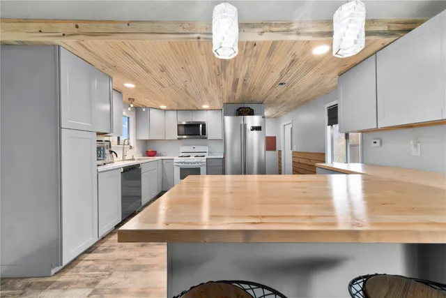 a kitchen with stainless steel appliances granite countertop a sink a stove and a refrigerator