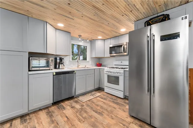 a kitchen with sink cabinets stainless steel appliances and a window