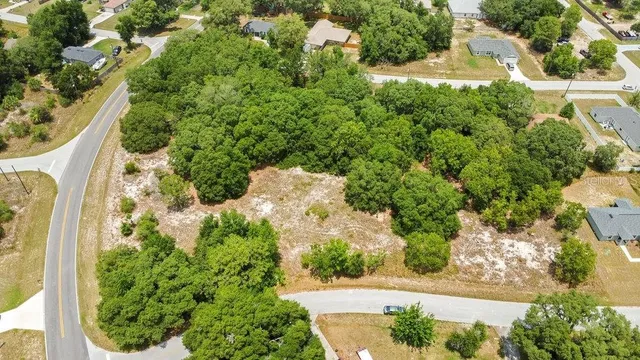 an aerial view of a house with a yard lake and outdoor seating