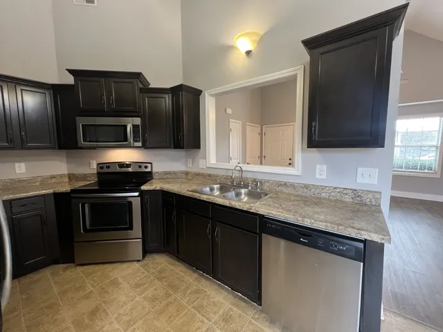 a kitchen with granite countertop stainless steel appliances and wooden cabinets
