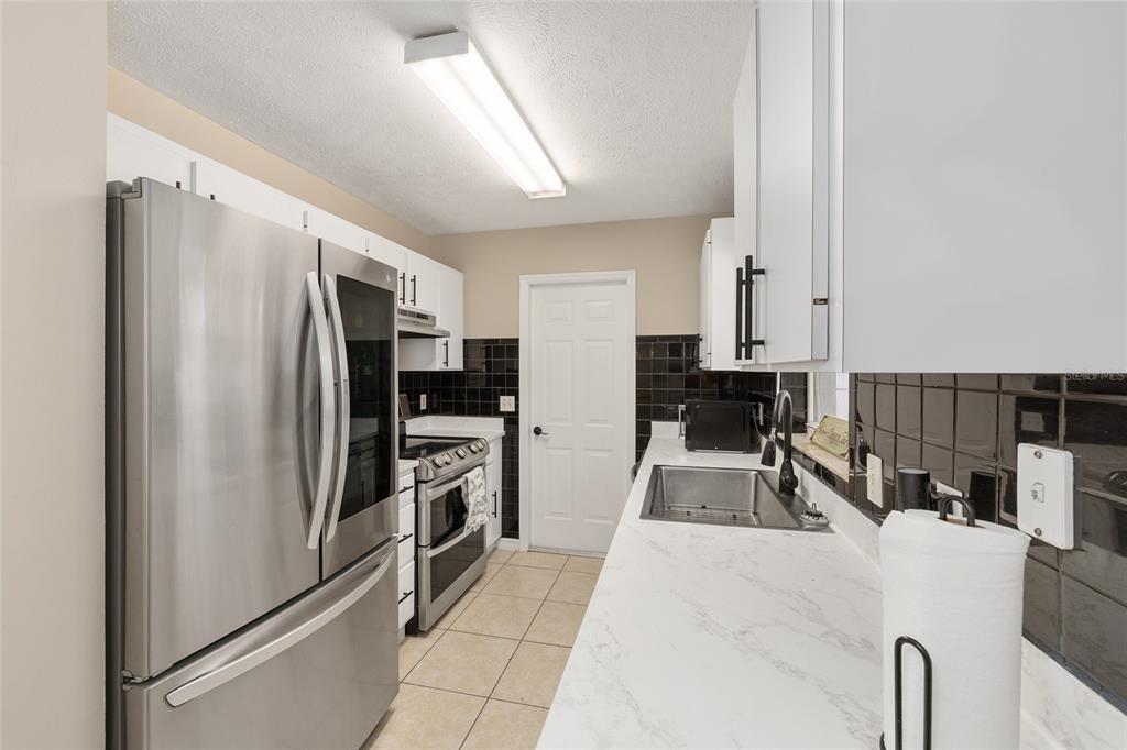 5255 Northwest 64 Street Ocala, FL 34482 - Photo 13 of 24 a kitchen with granite countertop a refrigerator and a sink