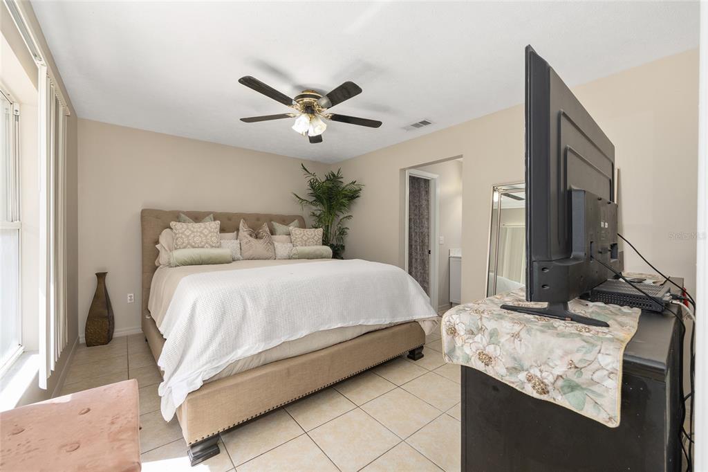 5255 Northwest 64 Street Ocala, FL 34482 - Photo 16 of 24 a bedroom with a bed and a chandelier