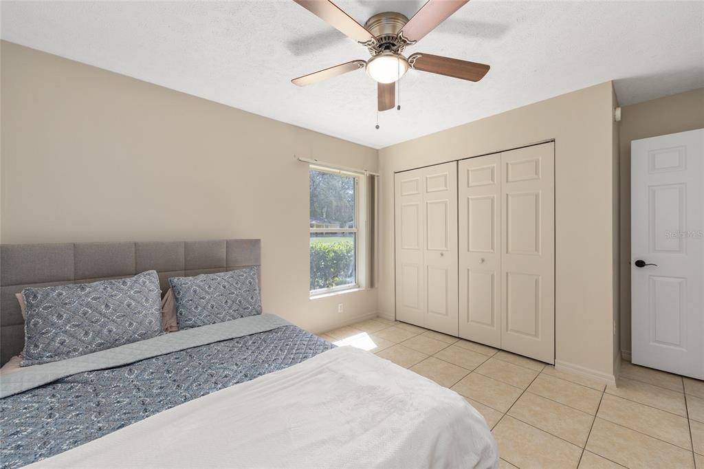 5255 Northwest 64 Street Ocala, FL 34482 - Photo 18 of 24 a spacious bedroom with a large bed and a chandelier fan