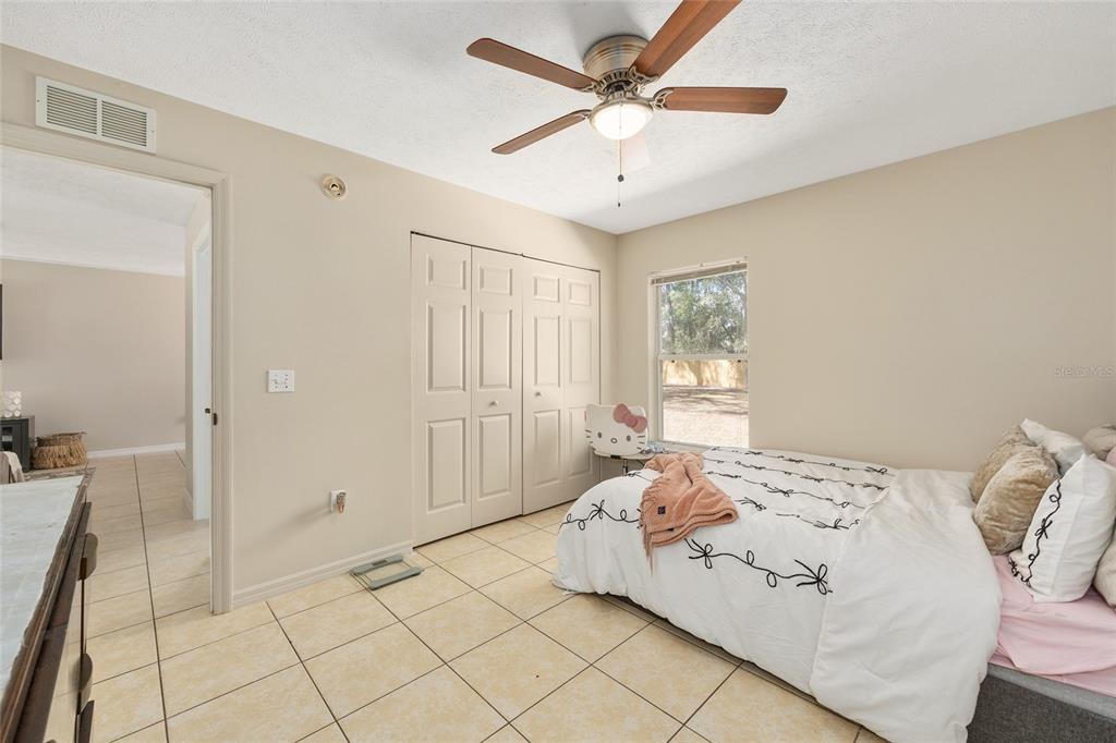 5255 Northwest 64 Street Ocala, FL 34482 - Photo 21 of 24 a spacious bedroom with a bed and a chandelier