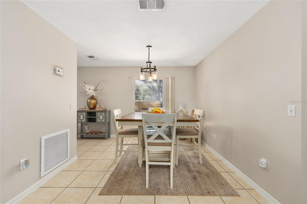 5255 Northwest 64 Street Ocala, FL 34482 - Photo 9 of 24 a dining room with chandelier and wooden floor