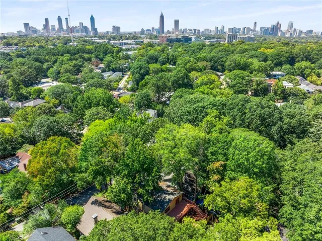 a view of an empty room with wooden floor fireplace and a window