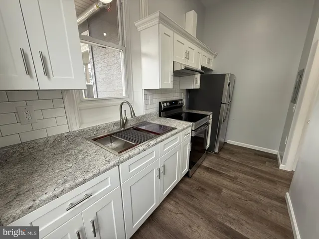 a kitchen with stainless steel appliances granite countertop a sink stove and cabinets