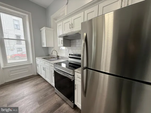 a kitchen with stainless steel appliances a refrigerator sink and cabinets